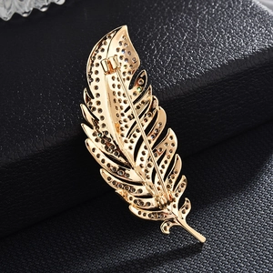 Detail view of the secure pin clasp and gold metal back of a zircon feather brooch