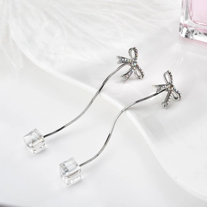 Eleganti orecchini a fiocco argento con lunghi ciondoli a cubo su piuma bianca