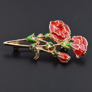 Fashionable carnation brooch with red enamel and crystals on a gold metal base