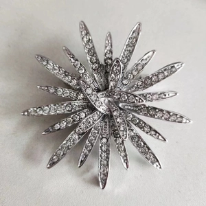 Exquisite silver sunflower brooch featuring radiant rhinestones in a starburst pattern