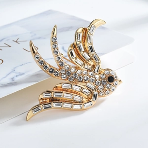 Vista macro detallada del broche de golondrina dorada con diamantes de imitación brillantes
