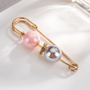 Detail view of elegant gold-plated alloy brooch with iridescent pearls and fine rhinestones