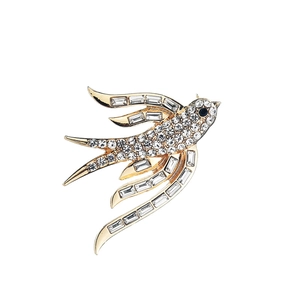 Detalle del broche de golondrina dorada con brillantes diamantes de imitación variados