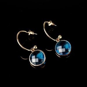 Elegante vintage gouden oorbellen met gefacetteerde diepblauwe kristallen op een zwarte achtergrond