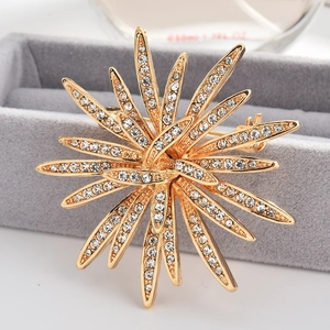 Elegant gold sunflower brooch with sparkling crystals on grey velvet jewelry box
