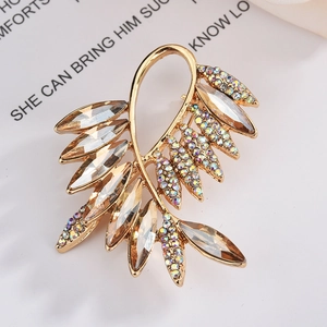 Élégante broche feuille dorée avec cristaux d'ambre et strass colorés sur carte blanche