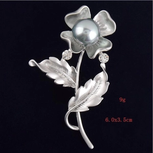 Detailed view of silver flower brooch with grey faux pearl and crystal accents, 6.0x3.5cm