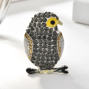Détail d'une broche hibou avec des strass gris et des accents en émail coloré