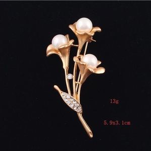 Detail view of the matte gold floral brooch with pearls and zircons measuring 5.9x3.1cm