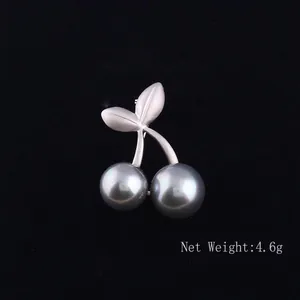 Detailed macro view of cherry flower brooch with matte silver leaves and grey pearls