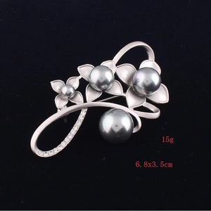 Detail view of flower brooch with grey pearls and crystals on matte silver petals