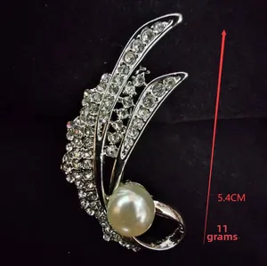 Macro view of crystal feather brooch with pearl detail and dimensions of 5.4cm