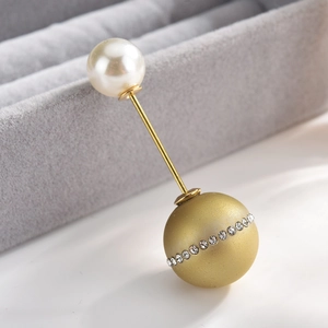 Macro shot of gold drop earring with creamy pearl and rhinestone-encrusted matte sphere