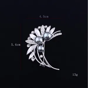 Detailed view of silver flower brooch with dark grey faux pearls and dimensions 4.5cm by 5.4cm