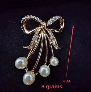 Detailed view of luxury bow pearl brooch with crystal tassels measuring 4cm and 8g weight