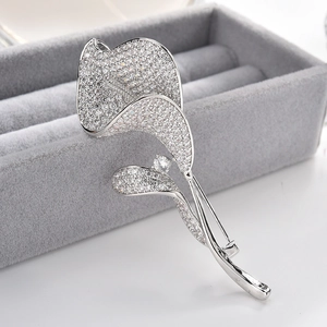 Élégante broche calla en argent sertie de zircons sur un écrin de présentation gris