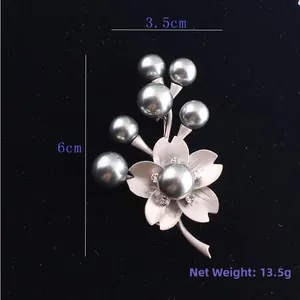 Detailed size view of silver flower brooch with grey pearls and crystals on velvet