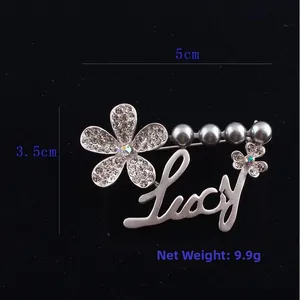 Detail view of flower brooch with faux grey pearls and Lucy lettering, size 5x3.5cm