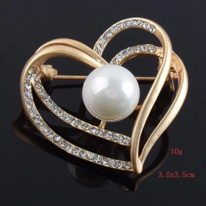 Close-up of double heart brooch with imitation shell pearl and sparkling rhinestones