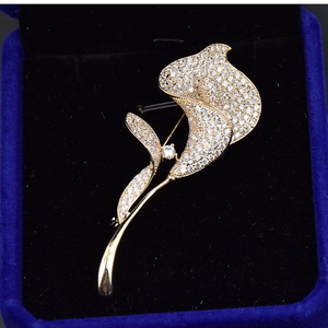 Broche élégante calla plaquée or avec zircons blancs dans son écrin à bijoux bleu