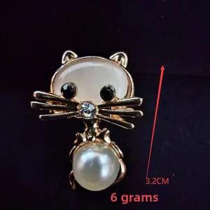 Detail shot of cute cat brooch with opal head and pearl body showing 3.2cm size