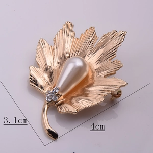 Détail macro de broche feuille d'érable dorée avec perle et cristaux 4cm x 3,1cm
