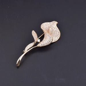 Détail de la broche fleur de calla en métal doré ornée de zircons cubiques brillants