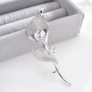 Macro detail of calla lily brooch with micro-pave cubic zirconia on velvet jewelry box