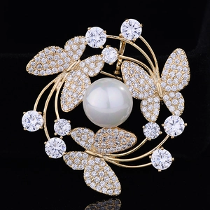 Elegante spilla a farfalla dorata con perla centrale e ghirlanda di zirconi su velluto
