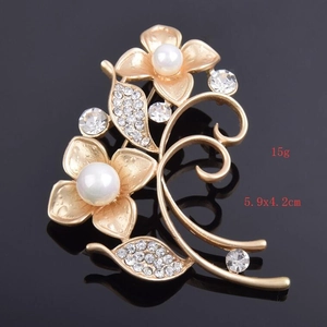 Detailed view of matte gold floral brooch with pearls and crystals, size 5.9x4.2cm