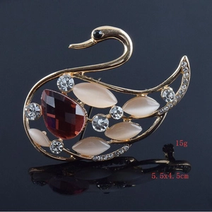Detail einer eleganten Schwan-Brosche mit rotem Edelstein und weißen Zirkonia-Steinen