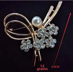 Detail shot of a 6cm flower brooch featuring white pearls and clear crystal rhinestones