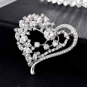 Détail d'une broche en forme de cœur avec zircons marquise et cristal central rond