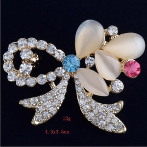 Dettaglio spilla a fiocco con strass e pietre occhio di gatto, 4.3x3.5cm e peso 12g