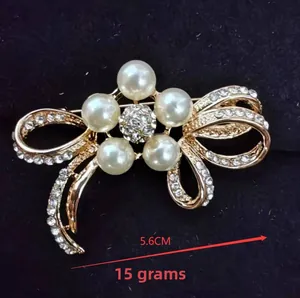 Detail of flower brooch with five large pearls and small white crystals on gold base