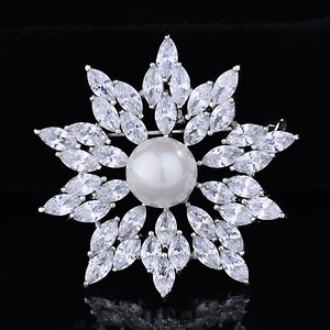 Elegant snowflake brooch with a large central pearl and sparkling zircon crystals