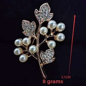 Detailed close-up of a floral brooch with faux pearls and rhinestones, 5.1cm long