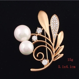 Detail view of matte gold brooch with shell pearls and zircons measuring 5.1x4.1cm