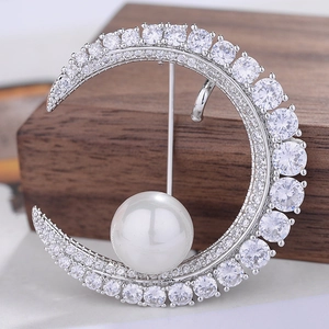 Elegant crescent moon brooch with shimmering zircons and a large white pearl detail