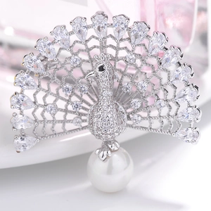 Macro detail of silver peacock brooch with micro-pave zircons and white pearl drop
