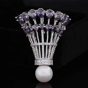 Détail macro de broche de badminton avec zircons violets et perle blanche sur fond noir