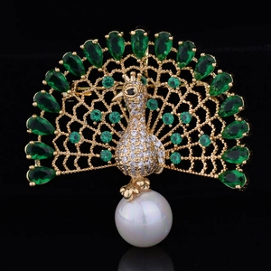 Detailed close-up of peacock brooch with green zircon feathers and a white pearl accent