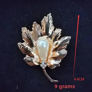 Detail view of a maple leaf brooch with a large pearl, measuring 4.4cm and weighing 9g