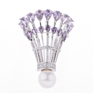 Détail de broche volant avec gemmes violettes, zircons scintillants et une grande perle blanche
