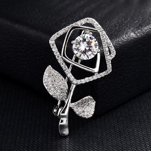 Détail d'une broche rose argentée avec pavage de zircons fins et cristal central brillant