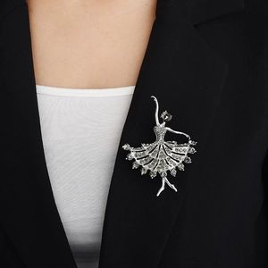 Detailed close-up of a silver ballet dancer brooch with rhinestones on a black suit lapel