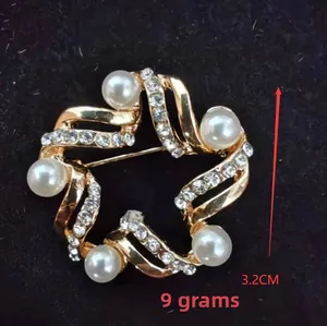 Macro detail of star-shaped golden brooch with white pearls and rhinestones 3.2cm size