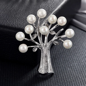 Macro d'une broche arbre en argent avec perles blanches sur fond en cuir noir élégant