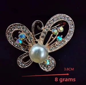 Macro shot of butterfly brooch with 3.8cm width featuring pearls and rhinestones