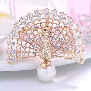 Elegant peacock brooch with sparkling zircons and white pearl drop on golden base